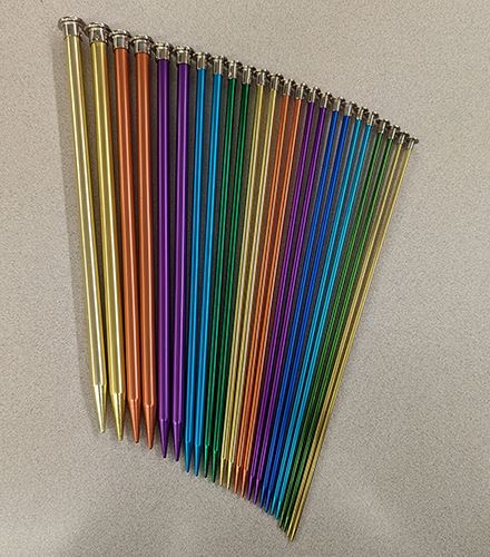 A photo of a collection of metal cylindrical knitting needles of various thicknesses.